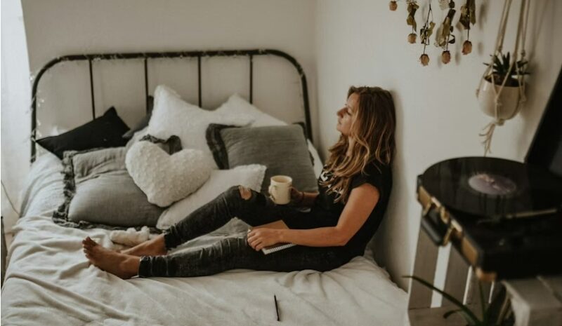 Woman relaxing on a bed during a daily digital detox.