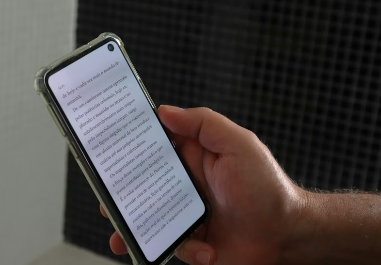 Hand holding a phone with an ebook loaded.